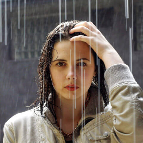 Woman touching her hair in the rain