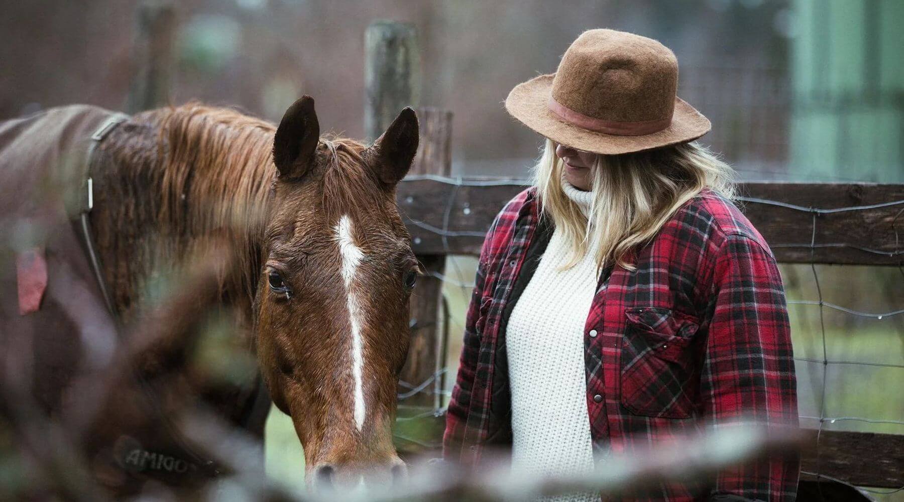 Woman with horse in corral